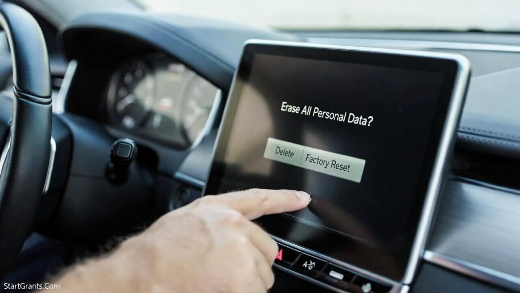 A driver deleting their saved home address and Bluetooth contacts from the car's navigation screen before a charity donation pick-up.