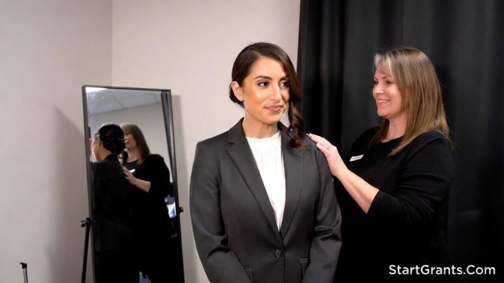 A woman trying on a free professional business suit at a Dress for Success boutique to prepare for a job interview.