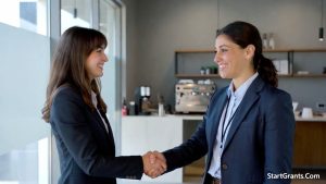 A nonprofit director shaking hands with a local business owner after successfully asking for a corporate donation