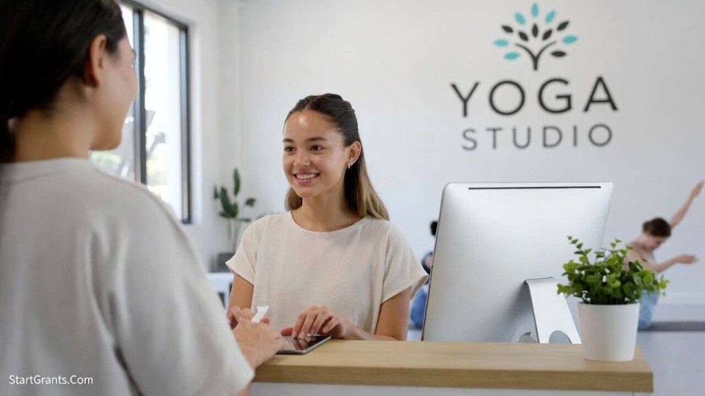 A yoga student working at the studio reception desk as part of a work-trade tuition agreement