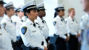 A focused police recruit in uniform training at a law enforcement academy
