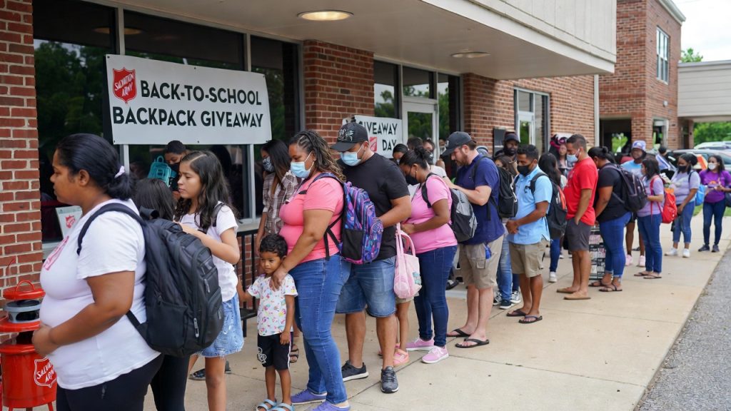 Families lining up at a Salvation Army back-to-school backpack giveaway event.