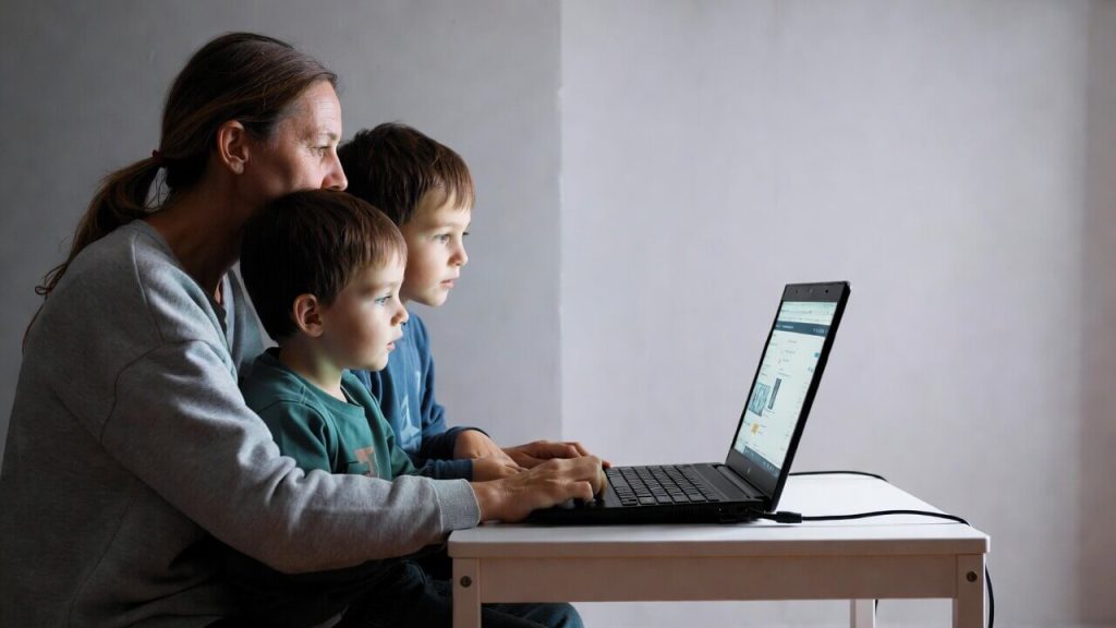 Low-income family sharing a single federally subsidized laptop due to the one-per-household rule.