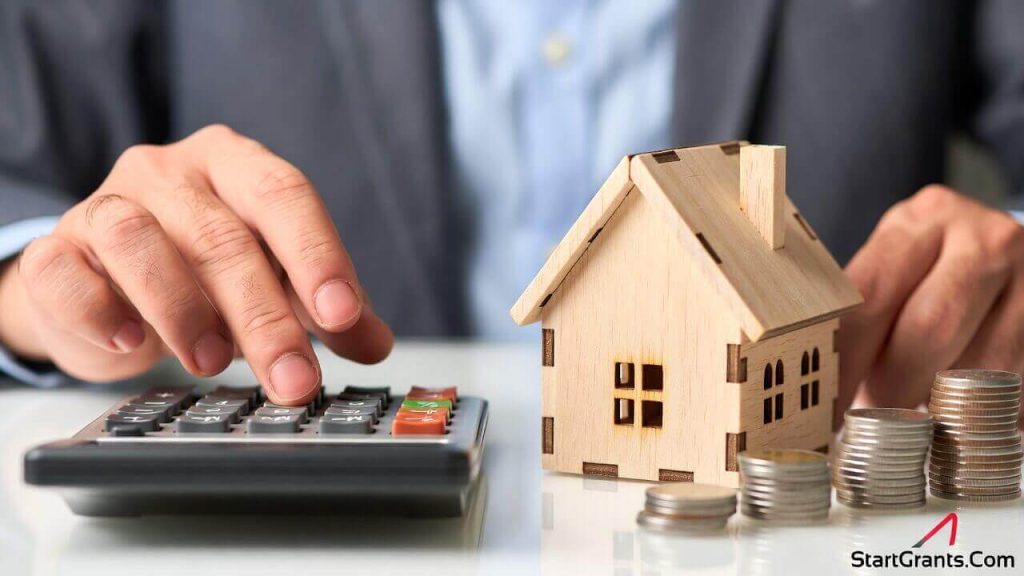 Hands calculating down payment assistance and closing costs for a new house.