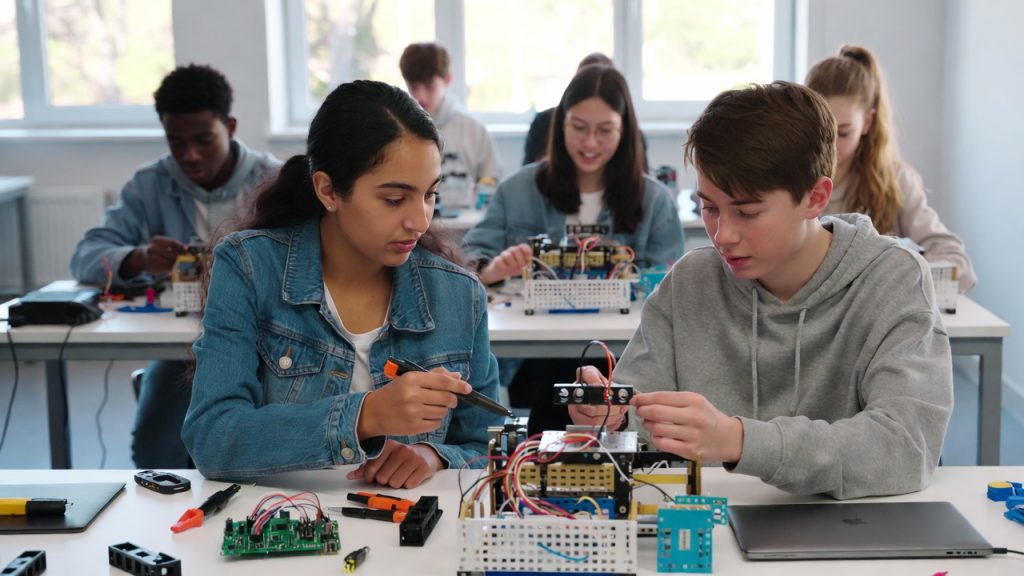 Students building a robot using a STEM grant in a modern classroom