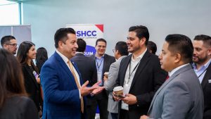 Hispanic professionals networking at a USHCC Chamber of Commerce event to find grant opportunities