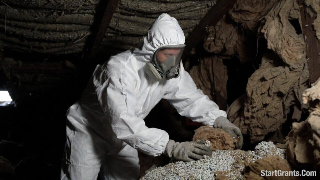A hazardous materials professional inspecting toxic attic insulation before a WAP weatherization upgrade.