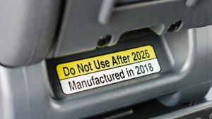 Close-up of a car seat manufacturing label showing the expiration date and model number.