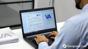 A veteran organizing medical paperwork and logging into the VA eBenefits portal on a laptop.