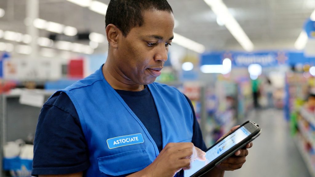 A Walmart associate looking at a tablet, representing the Live Better U education benefit.