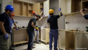 A Habitat for Humanity deconstruction crew carefully dismantling a kitchen for donation during a home remodel.