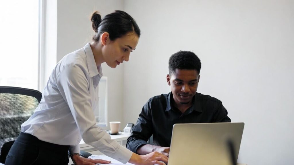 A case manager and a resident discussing a housing stability plan and paperwork at a desk.