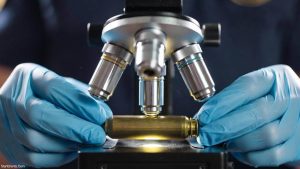 Analysis of a spent cartridge casing under a comparison microscope for the discipline of forensic ballistics.