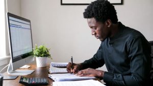 Minority business owner signing loan documents for capital expansion