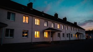 Exterior view of a modern transitional housing building with warm lighting, representing a safe, stable living environment.
