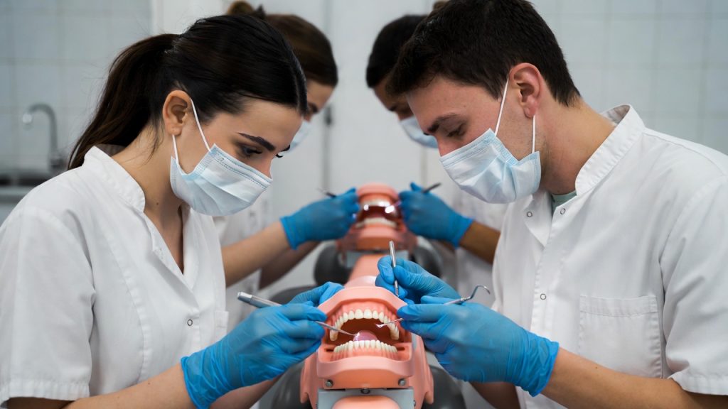 A group of dental hygiene students practicing scaling techniques on mannequin