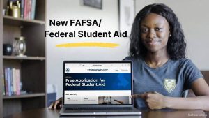 A cheerful female student uses a laptop to file her Free Application for Federal Student Aid (FAFSA) online to secure college grants.