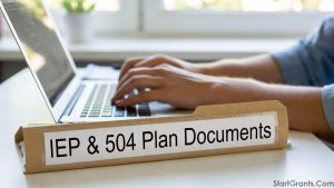 A student typing on a laptop next to an official IEP and 504 Plan folder