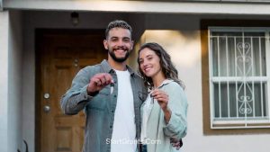 A happy young couple holding the keys to their new home, secured with first-time homebuyer government grants.