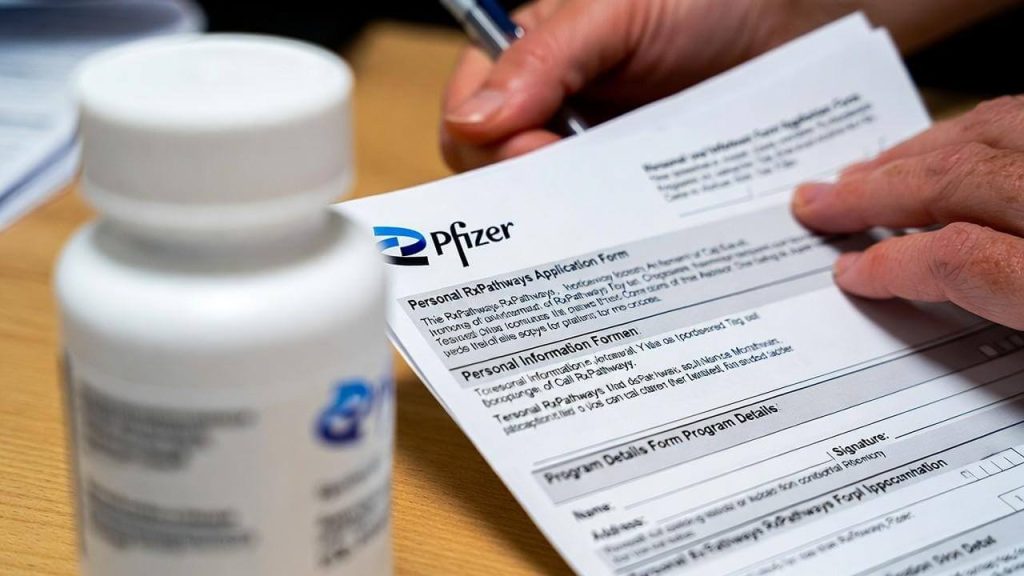 A patient filling out the Pfizer Patient Assistance Program application form for free medication.