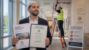 A Muslim community leader reviewing Halal grant documents for the installation of a fire sprinkler system in a Masjid.
